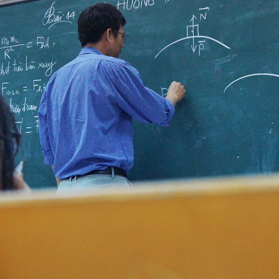 Photo of a teacher writing on a blackboard